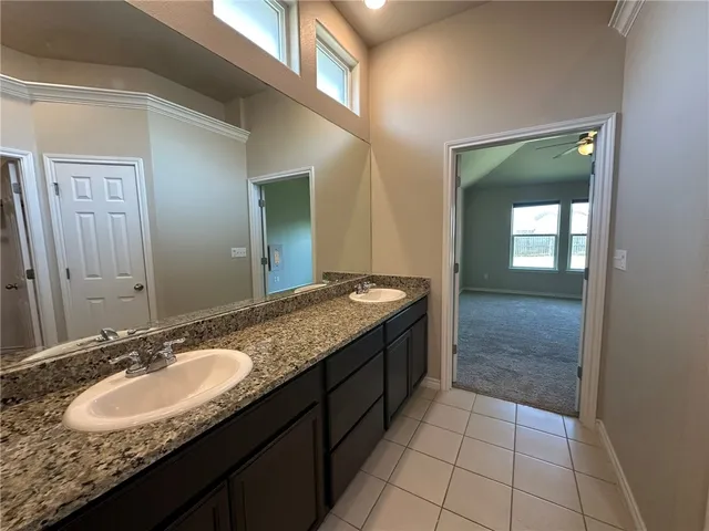 a bathroom with a granite countertop sink and a mirror