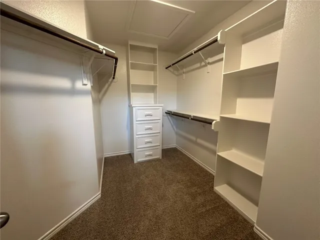 a view of walk in closet with clothes