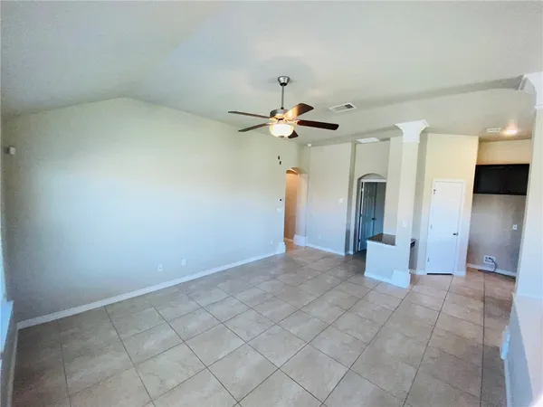 an empty room with a white walls and ceiling fan