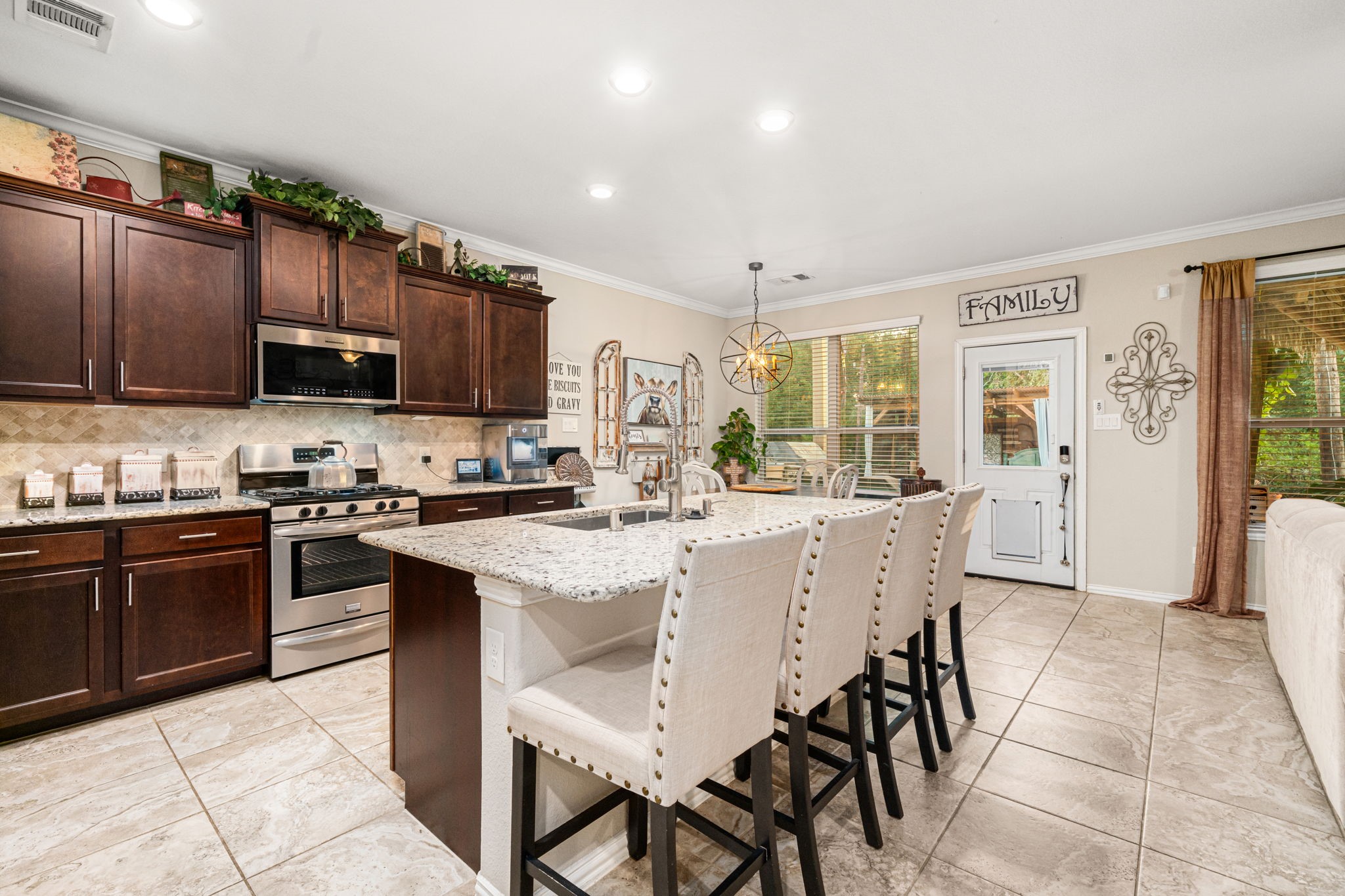 931 South Chamfer Way Crosby, TX 77532 - Photo 19 of 40 a kitchen with stainless steel appliances granite countertop a stove top oven a sink dishwasher a dining table and chairs with wooden cabinets