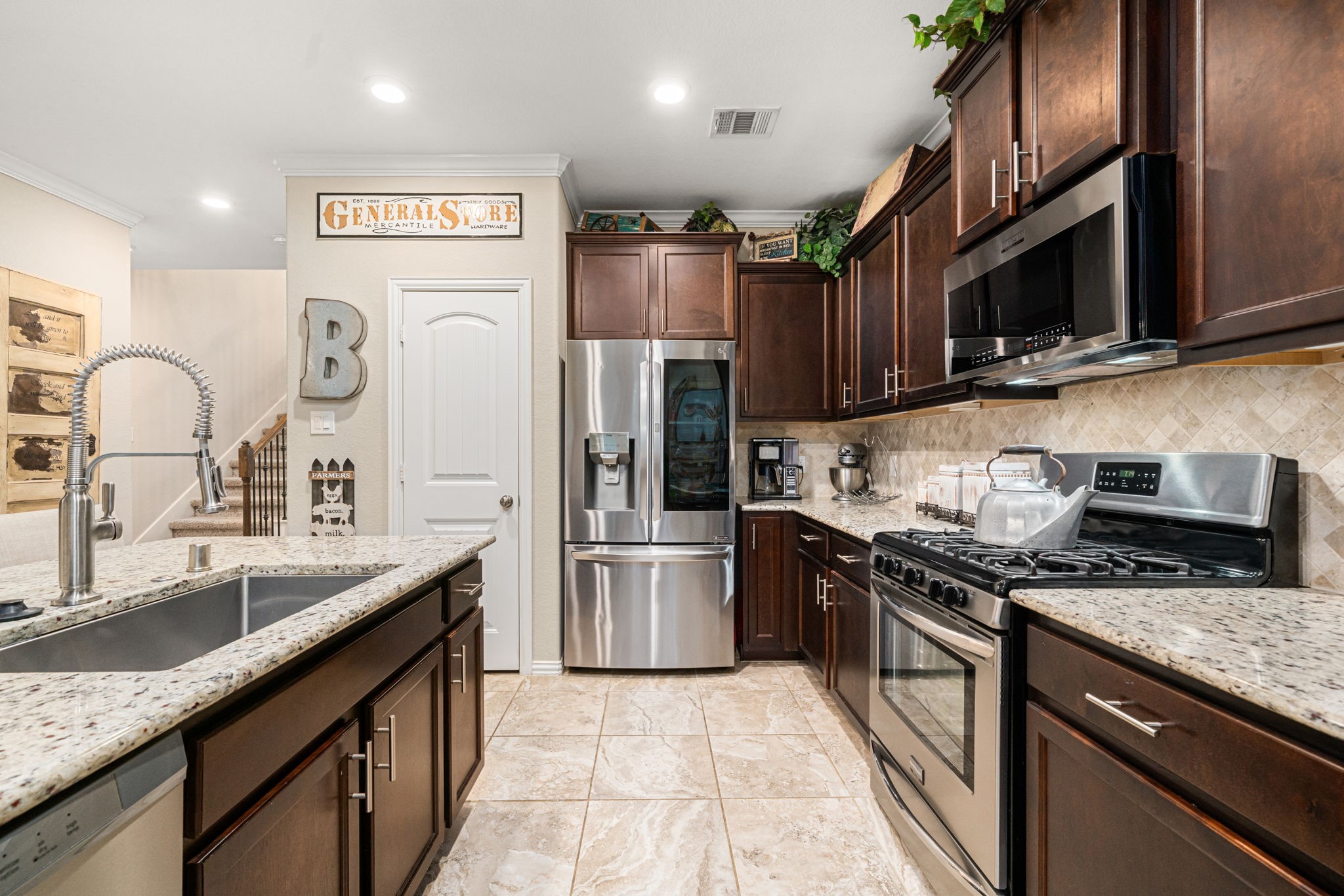 931 South Chamfer Way Crosby, TX 77532 - Photo 21 of 40 a kitchen with stainless steel appliances granite countertop a sink stove and refrigerator