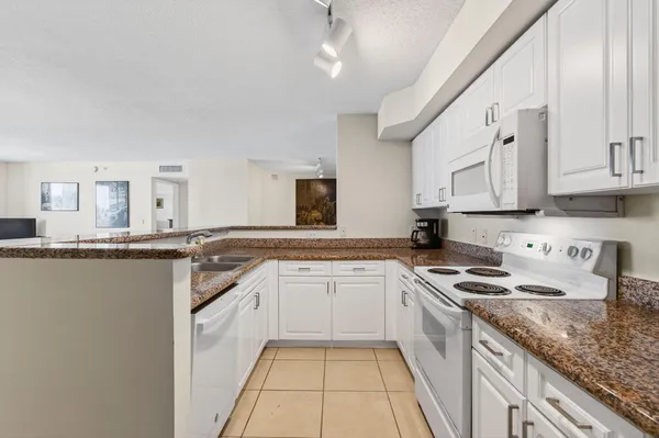 a kitchen with granite countertop a stove sink and cabinets