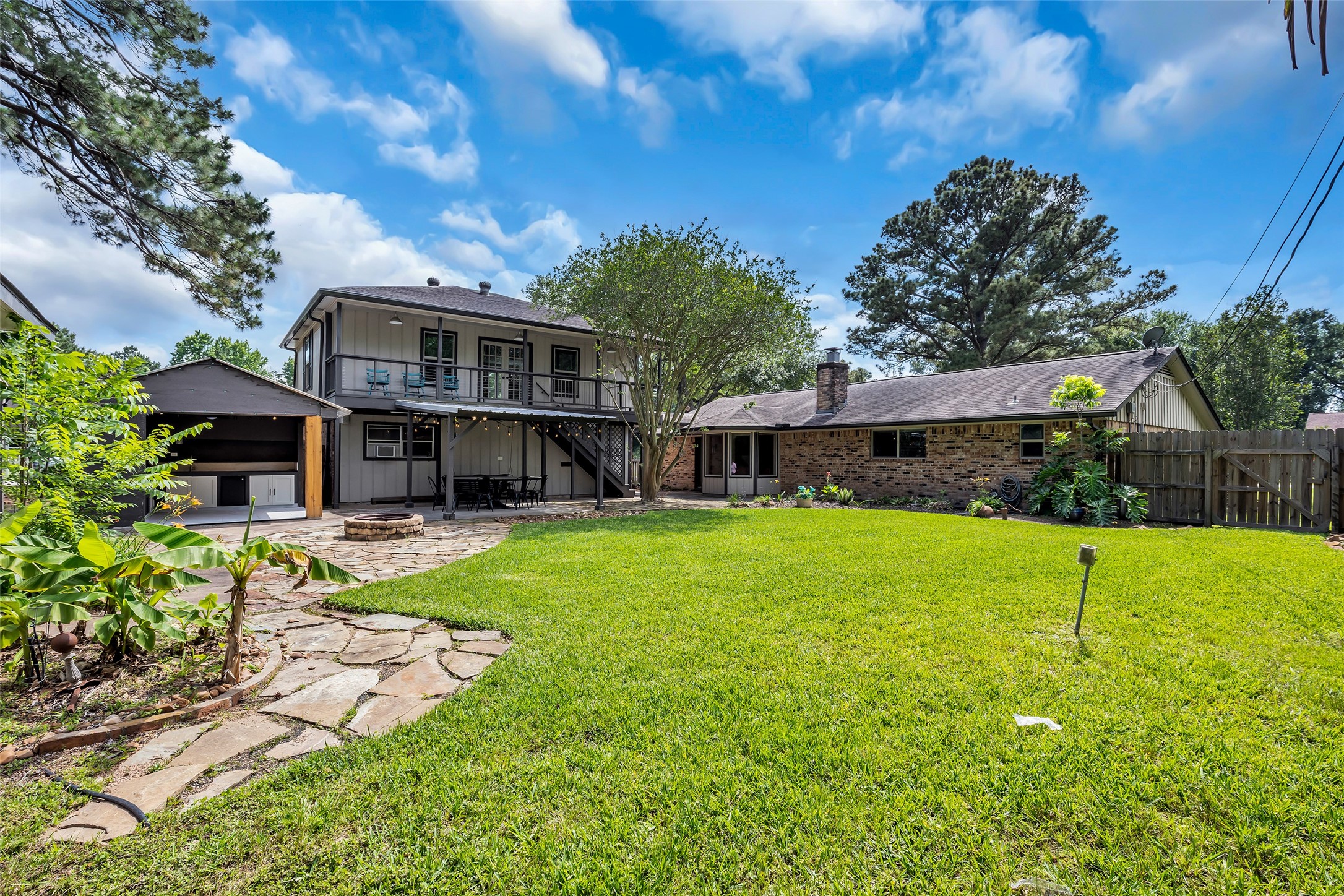 22502 Fields Lane Spring, TX 77389 - Photo 37 of 39 Spacious backyard with lush green grass, a stone patio, and a covered outdoor area.