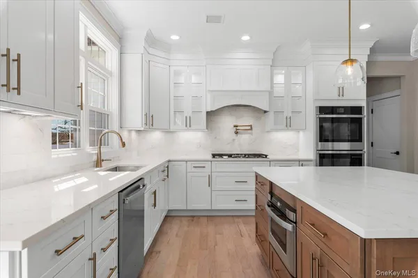 a kitchen with kitchen island granite countertop a sink a counter top stainless steel appliances and cabinets