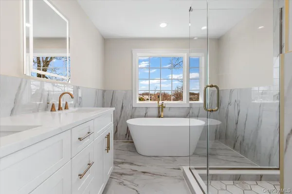 a spacious bathroom with double vanity and a mirror