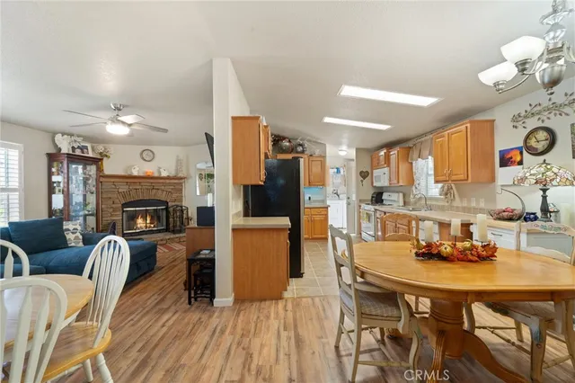 a kitchen with a refrigerator a sink dishwasher a dining table and chairs with wooden floor