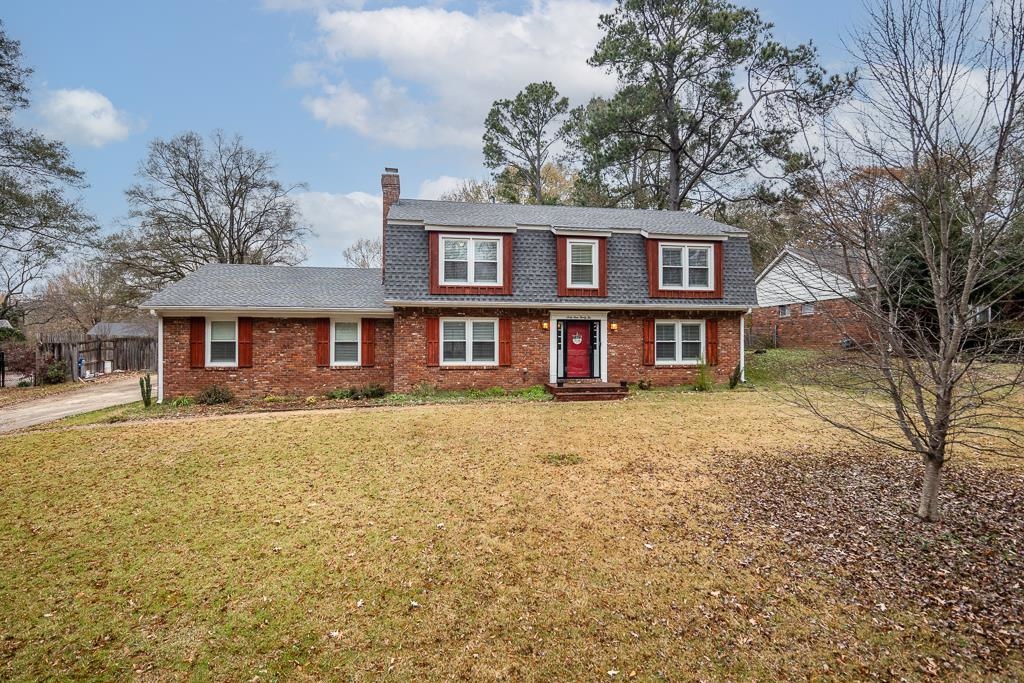 a front view of a house with yard and trees