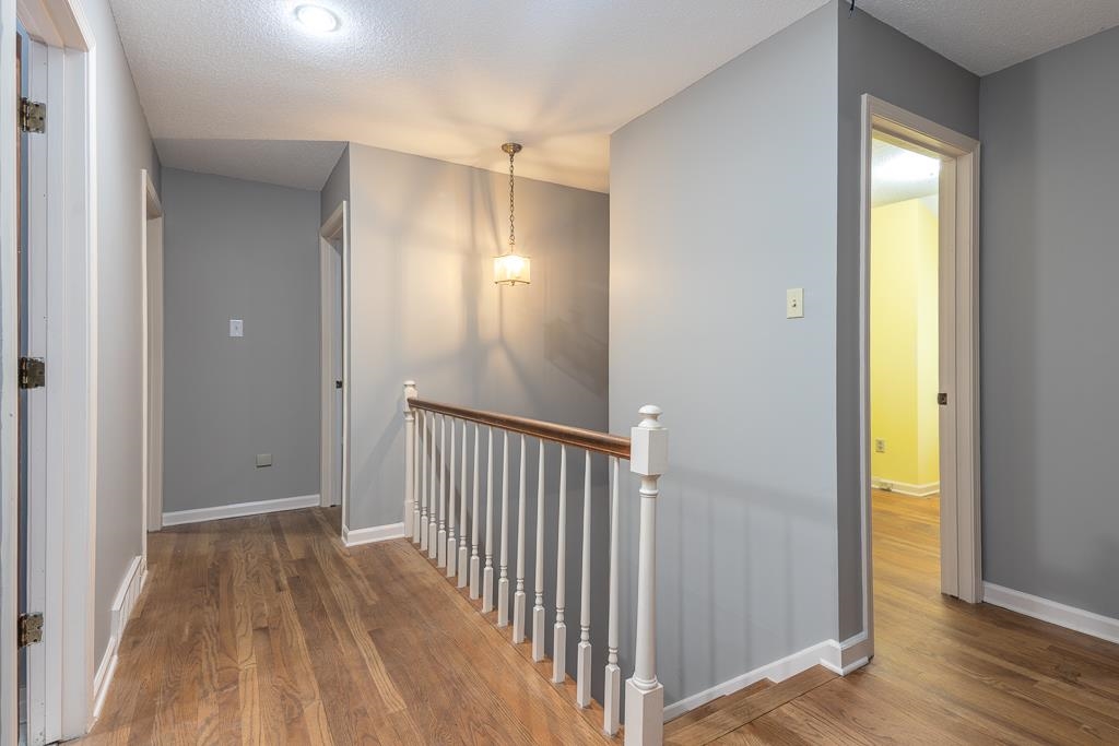 6932 Great Oaks Road Germantown, TN 38138 - Photo 12 of 20 a view of a hallway with wooden floor and a bathroom