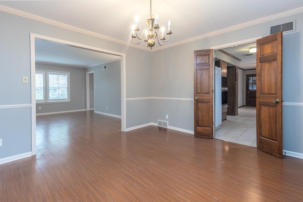 6932 Great Oaks Road Germantown, TN 38138 - Photo 4 of 20 a view of a hallway with wooden floor and a chandelier