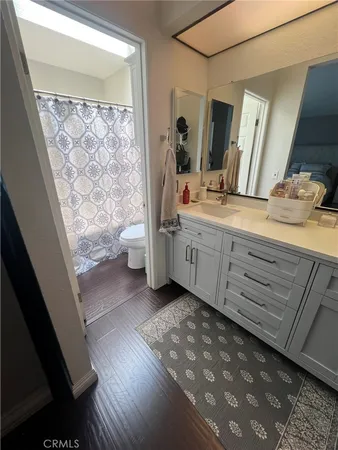 a bathroom with a double vanity sink toilet and mirror