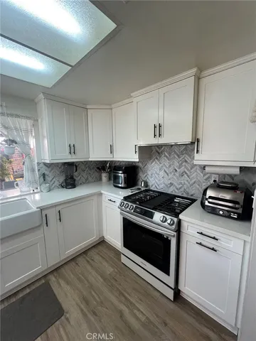 a kitchen with granite countertop white cabinets and appliances