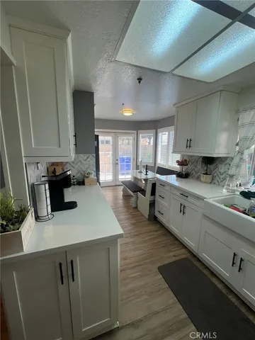 a kitchen with sink refrigerator and cabinets