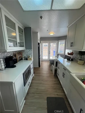 a large white kitchen with lots of counter space and wooden floor