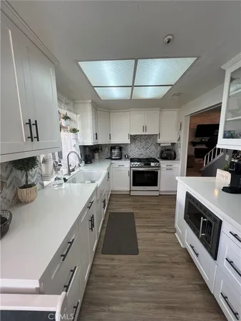 a large kitchen with stainless steel appliances granite countertop a lot of counter space and wooden floor