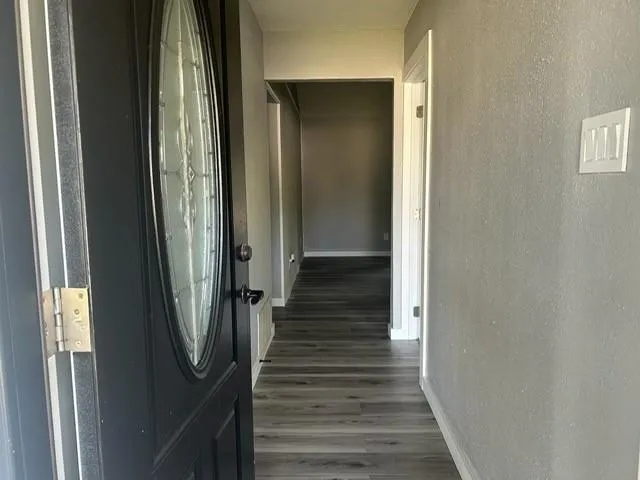 a view of a hallway with wooden floor and staircase