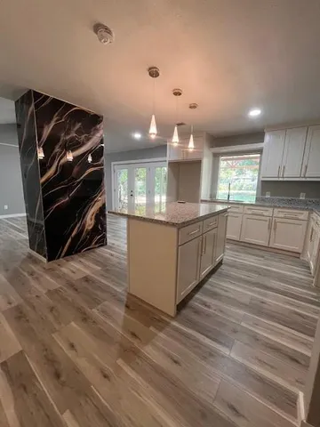 a kitchen with stainless steel appliances kitchen island granite countertop a stove and a cabinets