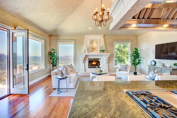 a living room with furniture and a dining table with wooden floor