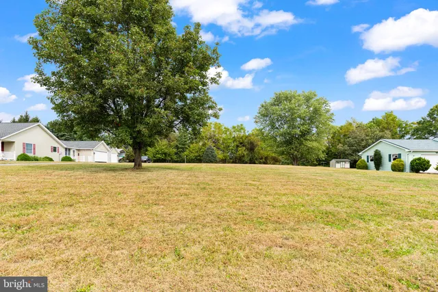 a view of an house with pool and trees in the background