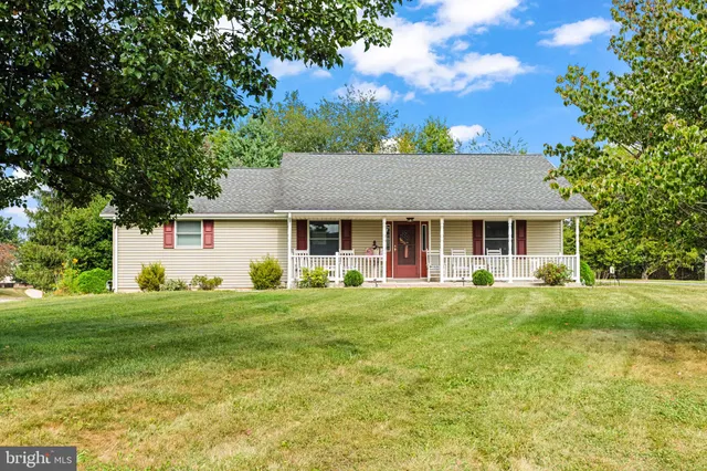 a front view of a house with a garden and trees