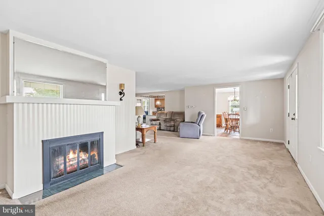 a living room with furniture a fireplace and a window