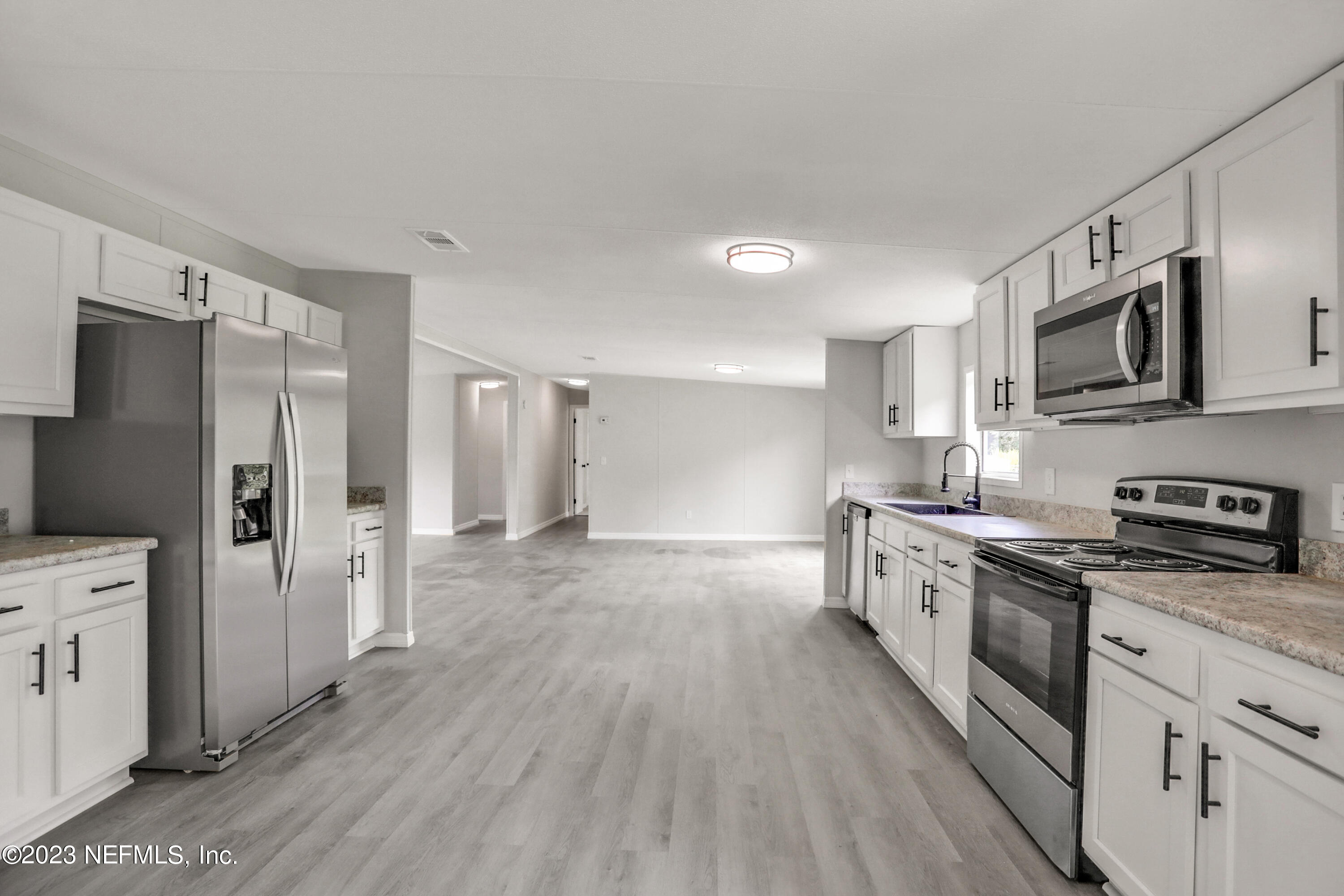 10765 Boddens Road Jacksonville, FL 32219 - Photo 21 of 39 a kitchen with stainless steel appliances a refrigerator stove microwave and cabinets