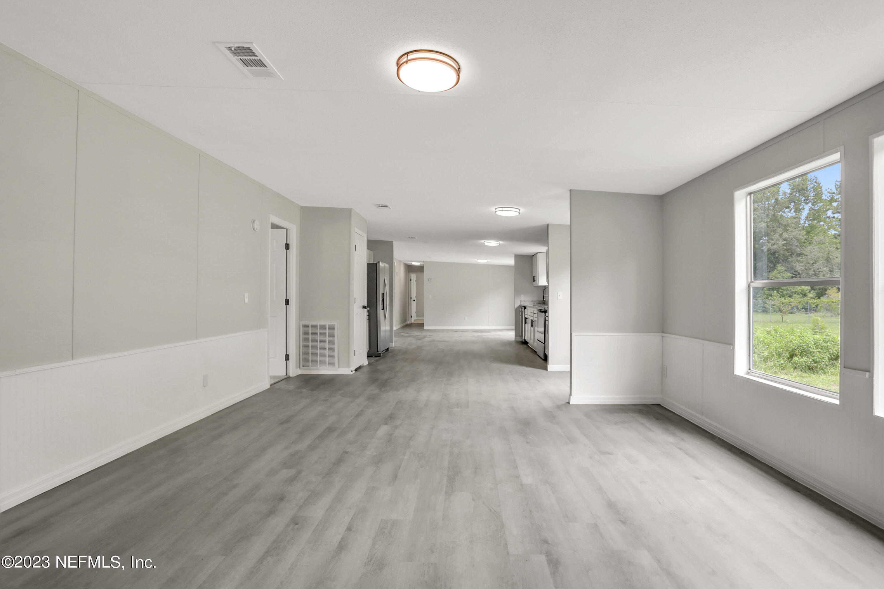 10765 Boddens Road Jacksonville, FL 32219 - Photo 24 of 39 a view of an empty room with a window and wooden floor