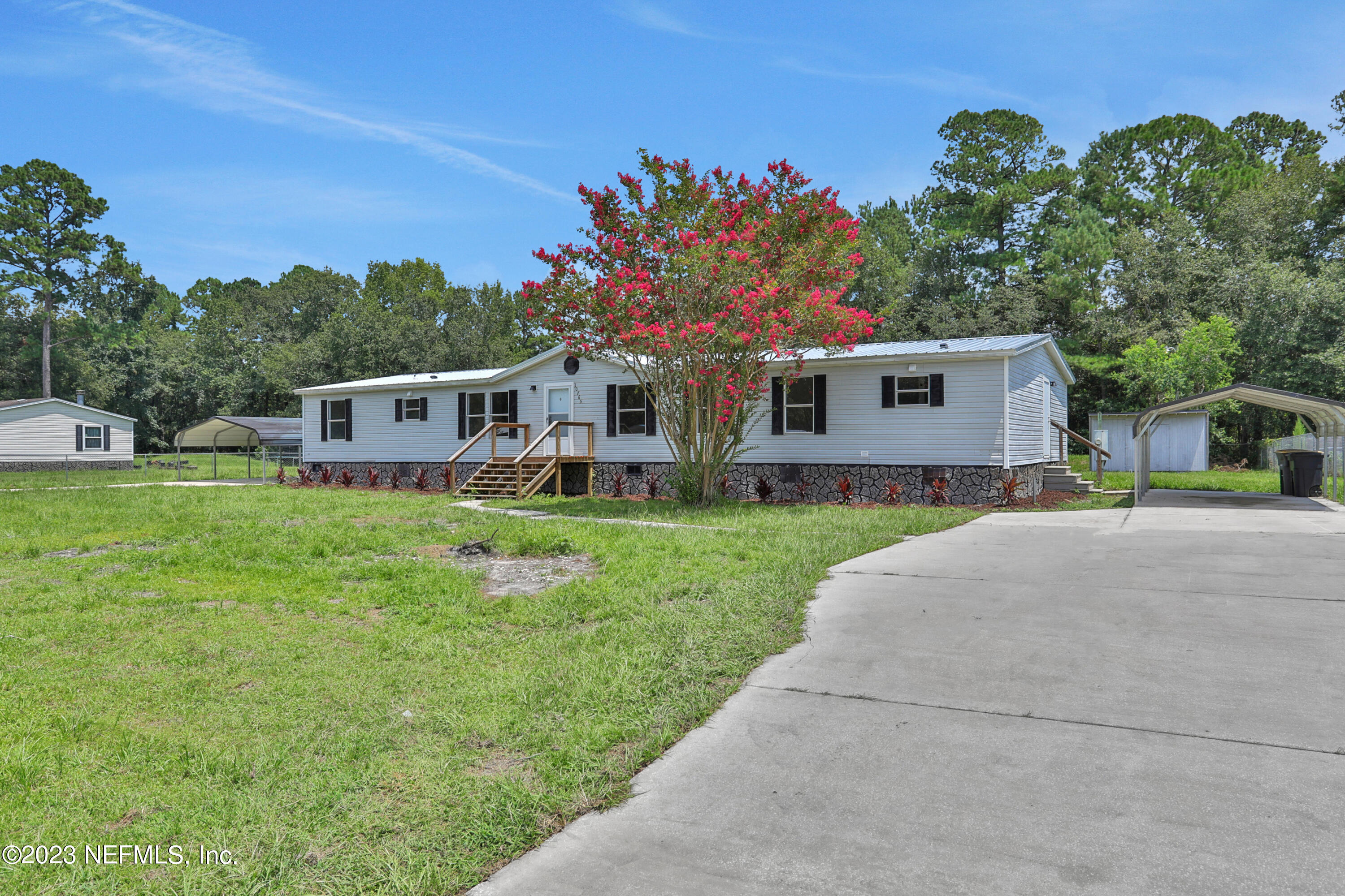 10765 Boddens Road Jacksonville, FL 32219 - Photo 3 of 39 a front view of a house with a yard table and chairs