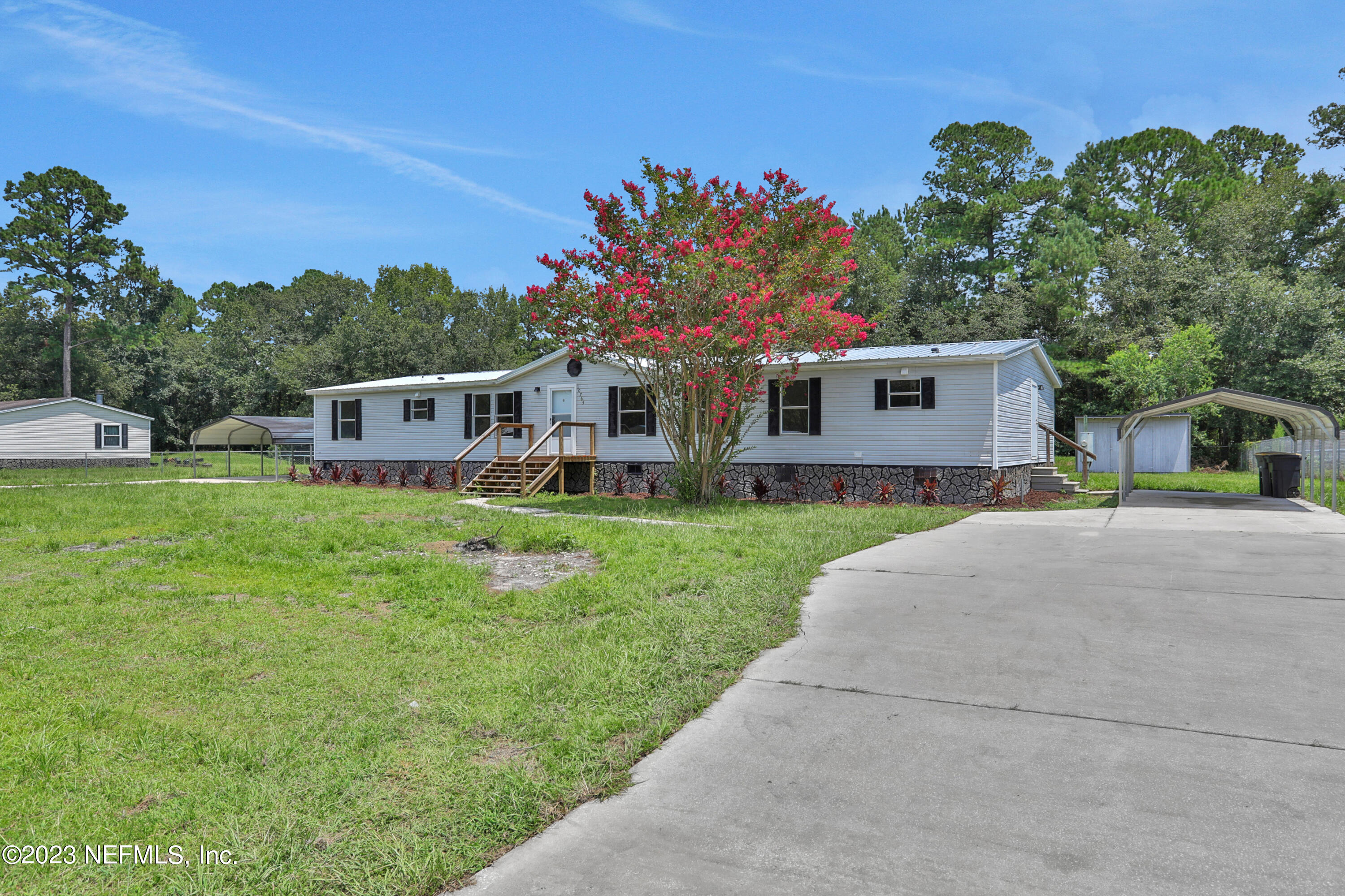 10765 Boddens Road Jacksonville, FL 32219 - Photo 4 of 39 a front view of a house with a yard table and chairs