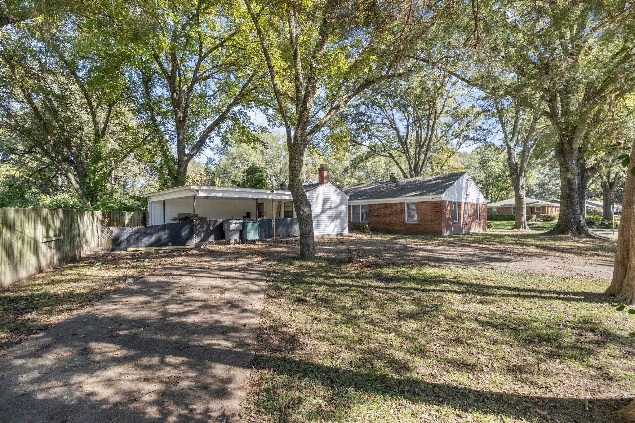 1435 Flamingo Road Memphis, TN 38117 - Photo 26 of 29 a front view of a house with a garden and trees