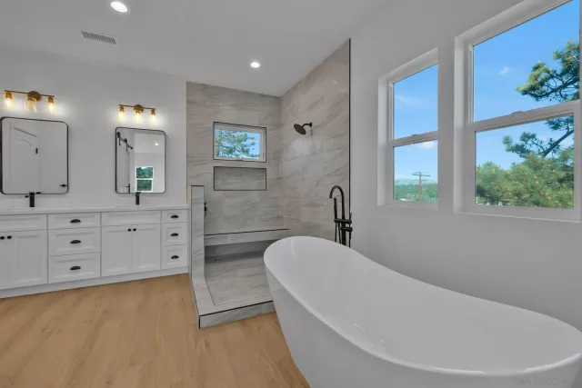 a view of a house with a small yard and large trees