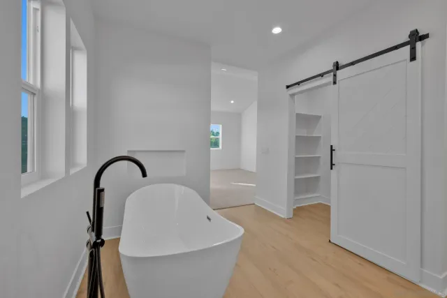 a view of a house with a yard plants and large tree