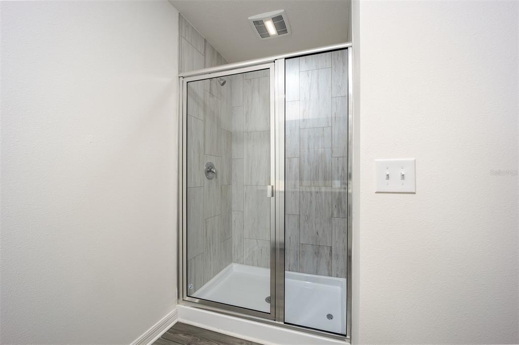 793 Poppy Lane Dundee, FL 33838 - Photo 12 of 16 a bathroom with a glass shower door