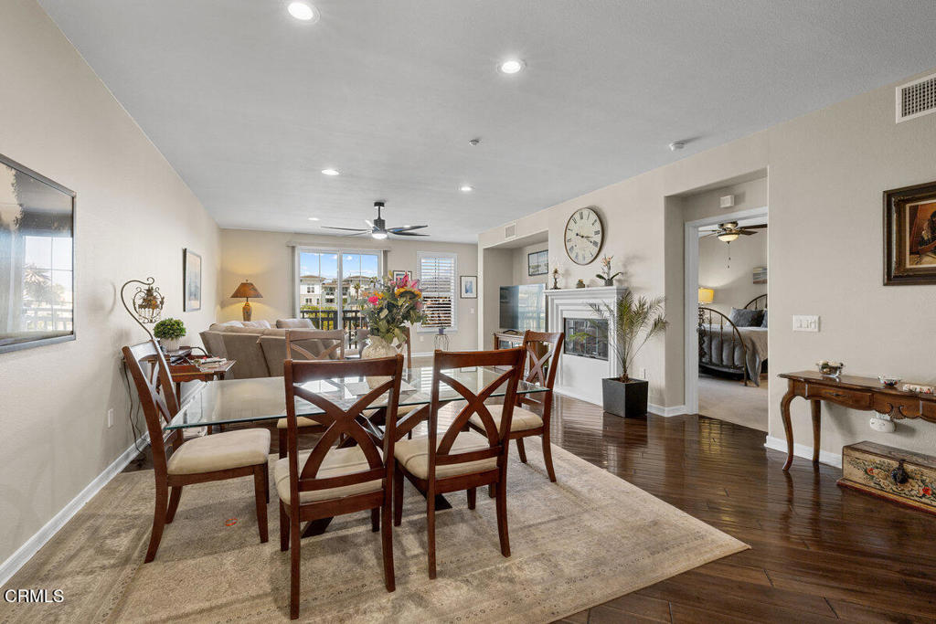 1544 Seabridge Lane Oxnard, CA 93035 - Photo 13 of 30 a view of a dining room and livingroom with furniture wooden floor a rug a painting and a chandelier