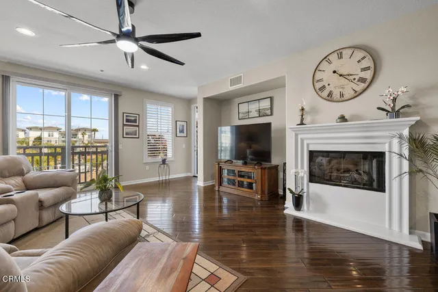 a living room with furniture a fireplace and a flat screen tv
