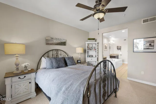 a bedroom with a large bed and a chandelier