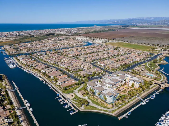 an aerial view of ocean and residential houses with outdoor space
