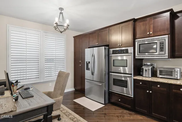 a kitchen with stainless steel appliances granite countertop a refrigerator and microwave