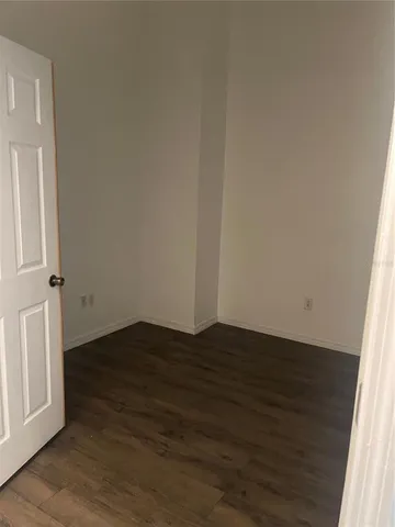 an empty room with wooden floor and door