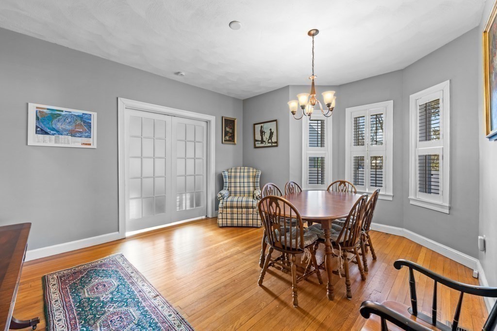 29-31 Middlesex Street, Unit 1 Chelmsford, MA 01863 - Photo 12 of 31 a dining room with furniture a chandelier and wooden floor