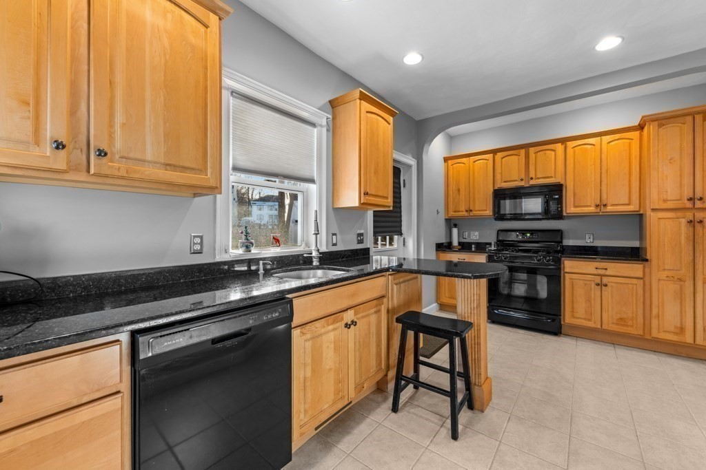29-31 Middlesex Street, Unit 1 Chelmsford, MA 01863 - Photo 5 of 31 a kitchen with stainless steel appliances granite countertop a stove a sink and a microwave