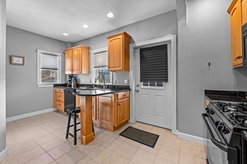 29-31 Middlesex Street, Unit 1 Chelmsford, MA 01863 - Photo 6 of 31 a kitchen with granite countertop a stove a sink and a refrigerator
