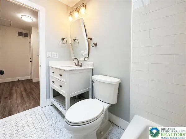 a bathroom with a toilet a sink and mirror