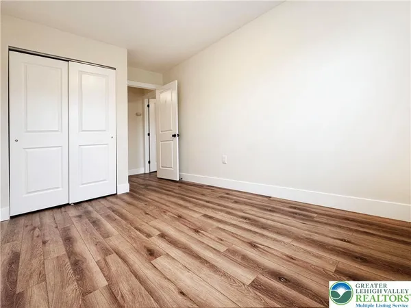 a view of an empty room with wooden floor