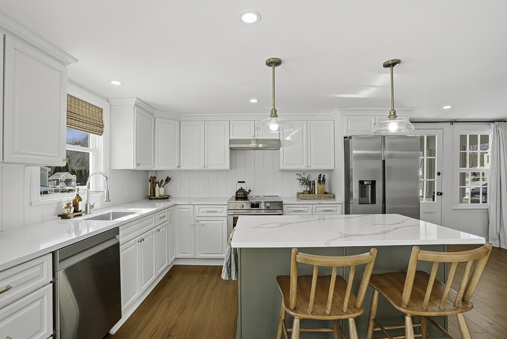 26 Maple Street Mendon, MA 01756 - Photo 11 of 42 a kitchen with a dining table chairs sink and cabinets