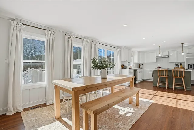 a living room with furniture a wooden floor and next to a window