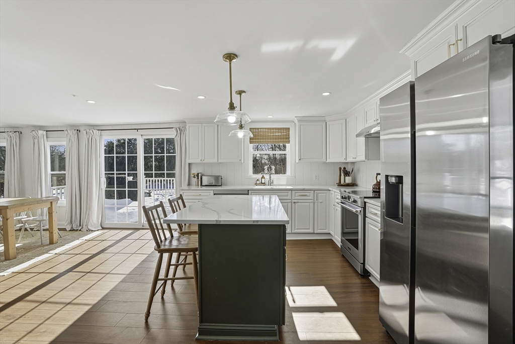 26 Maple Street Mendon, MA 01756 - Photo 7 of 42 a kitchen with stainless steel appliances kitchen island granite countertop a refrigerator a stove a kitchen island with a dining table and chairs