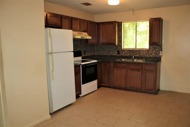a kitchen with a refrigerator sink and cabinets