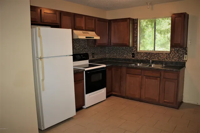 a kitchen with a refrigerator sink and cabinets
