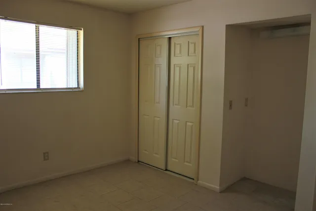 an empty room with windows and closet