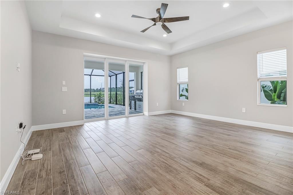 4652 Centaurus Circle Naples, FL 34120 - Photo 11 of 45 Spare room with a ceiling fan, a tray ceiling, healthy amount of natural light, light wood-style floors, and recessed lighting